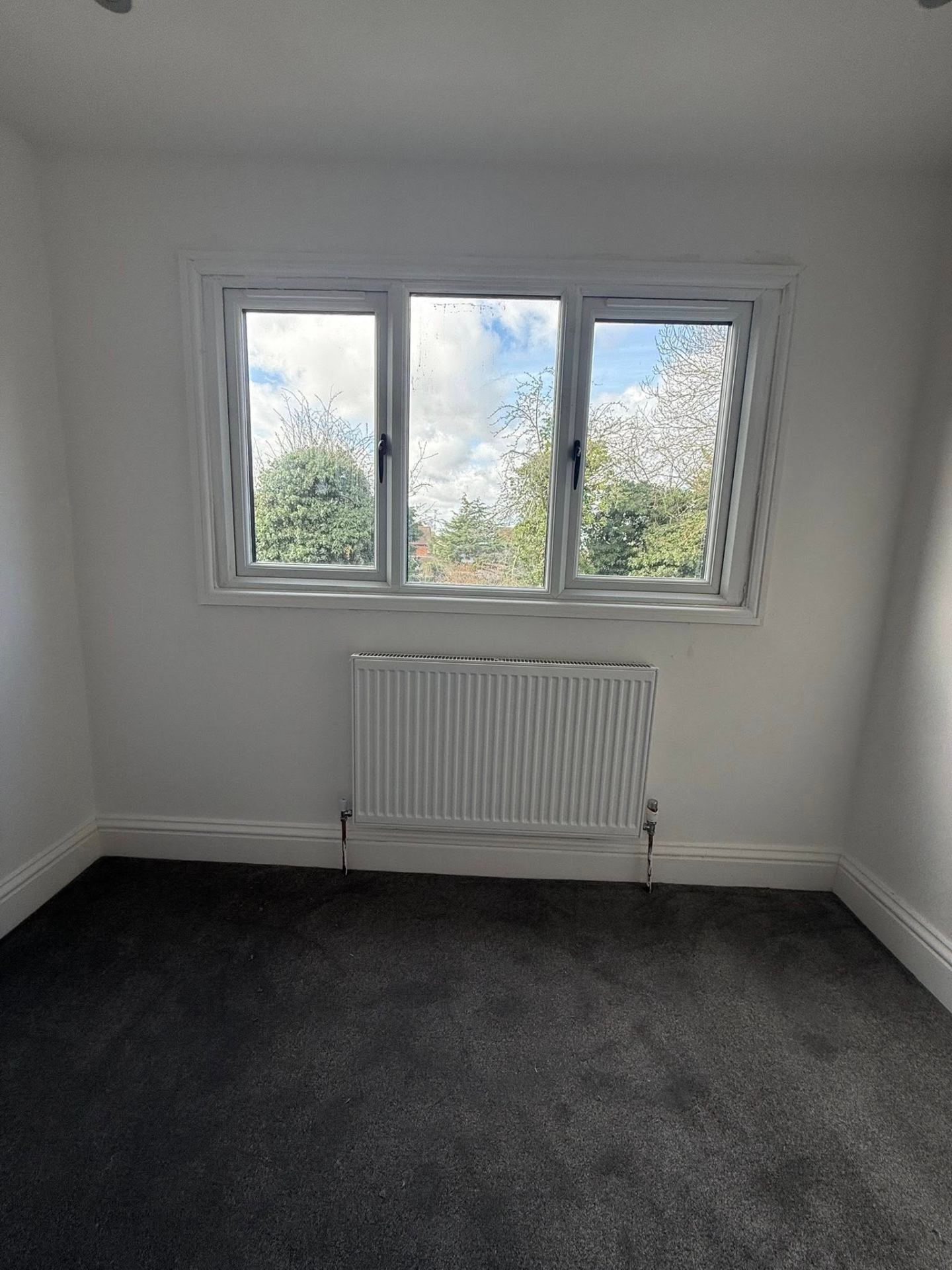 New compact radiator installation under a bedroom window in a Northampton home by J Lamb Plumbing & Heating
